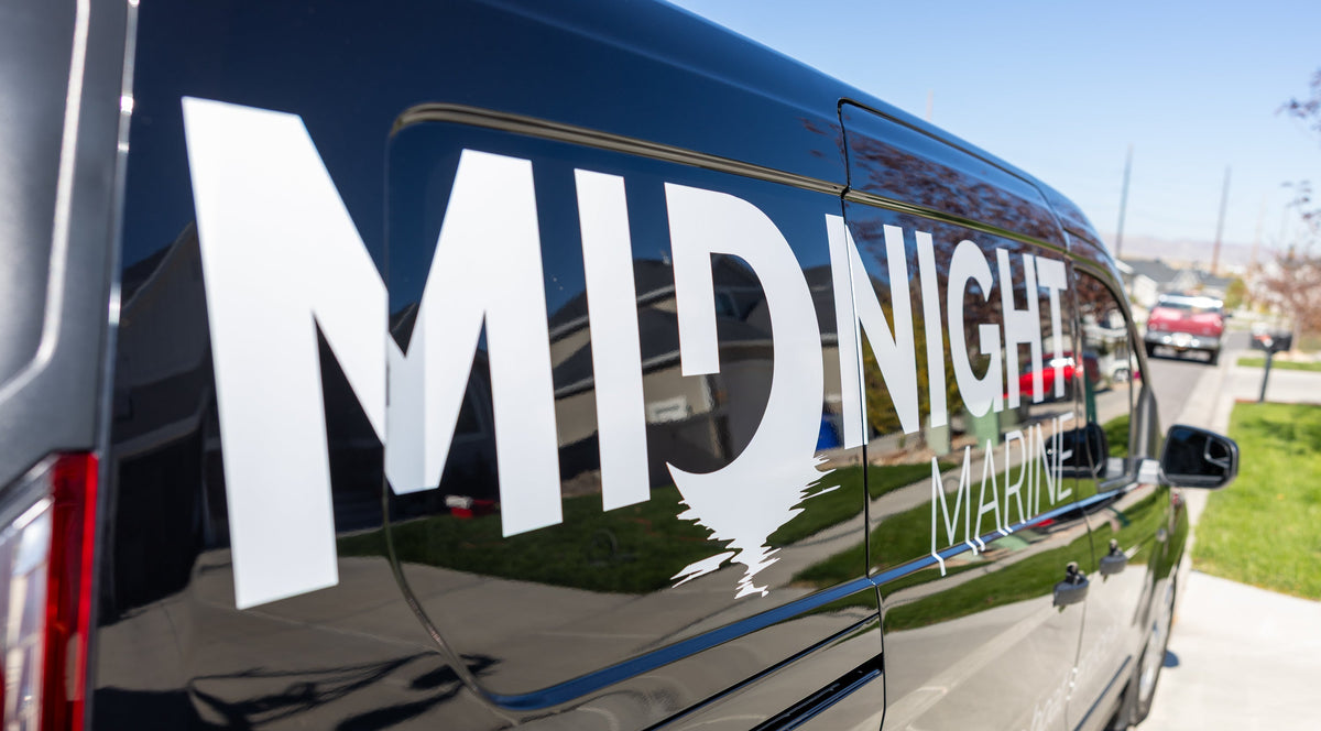 Black vehicle with 'Midnight Marine' logo on a street